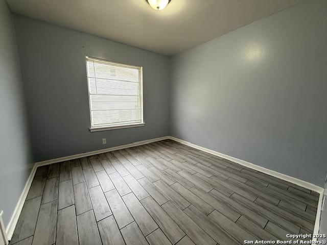 4519 Creekmoor, San Antonio, TX 78220 - spare room featuring dark wood-style flooring and baseboards