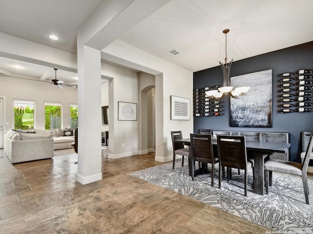 7211 Cresta Bulivar, San Antonio, TX 78256 - dining room featuring visible vents, arched walkways, baseboards, ceiling fan with notable chandelier, and stone tile floors