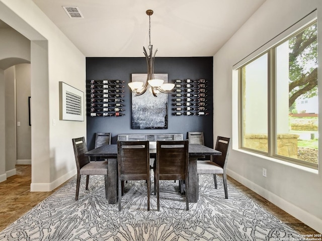 7211 Cresta Bulivar, San Antonio, TX 78256 - dining space featuring arched walkways, a chandelier, baseboards, wood finished floors, and visible vents