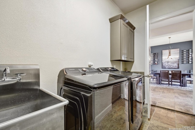 7211 Cresta Bulivar, San Antonio, TX 78256 - laundry room with cabinet space, a textured wall, a sink, and washing machine and clothes dryer