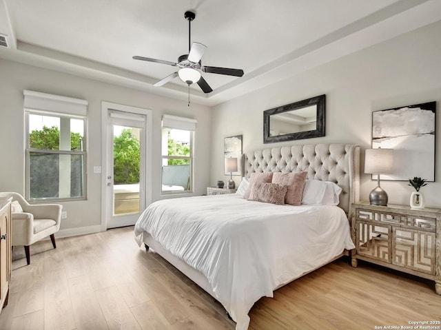 7211 Cresta Bulivar, San Antonio, TX 78256 - bedroom with access to outside, light wood-style floors, a tray ceiling, and multiple windows