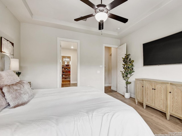 7211 Cresta Bulivar, San Antonio, TX 78256 - bedroom featuring ceiling fan, baseboards, a raised ceiling, and light wood-type flooring