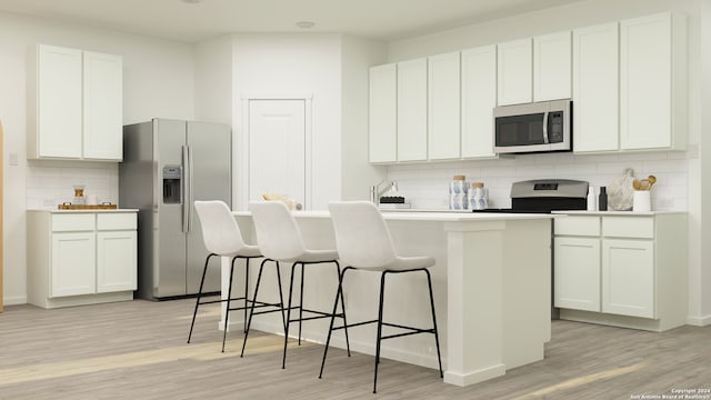 kitchen with appliances with stainless steel finishes, a breakfast bar area, light wood-style flooring, decorative backsplash, and a center island with sink