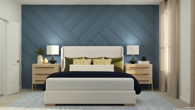 bedroom with baseboards, a decorative wall, and light colored carpet