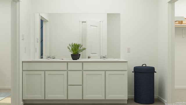 bathroom with double vanity, a sink, and baseboards