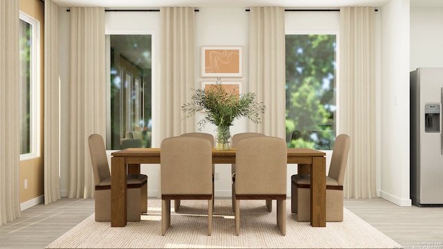 dining space featuring baseboards and light wood-style flooring