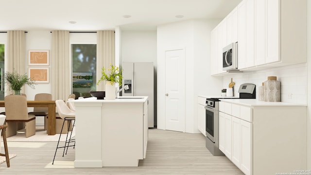 kitchen with electric range, a kitchen island with sink, a breakfast bar area, white cabinets, and light wood finished floors
