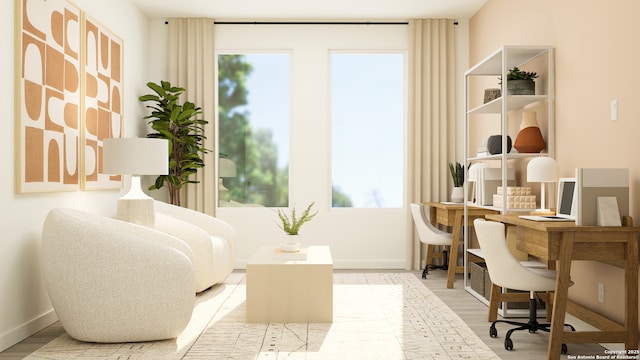 sitting room with baseboards, light wood-style flooring, and a wealth of natural light