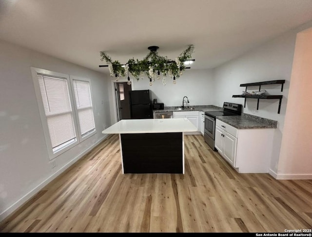 kitchen featuring a sink, white cabinets, black appliances, and light wood finished floors