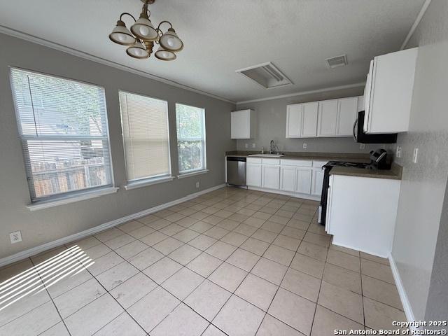 kitchen featuring black microwave, dishwasher, a sink, light tile patterned floors, and ornamental molding