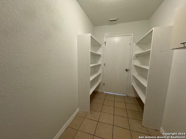 spacious closet featuring light tile patterned flooring and visible vents