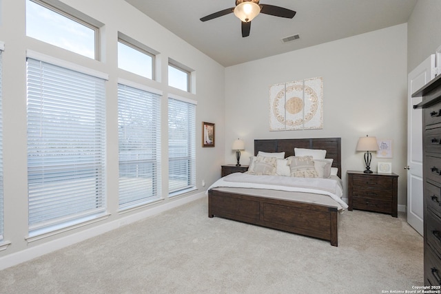 bedroom with visible vents, a ceiling fan, and light colored carpet