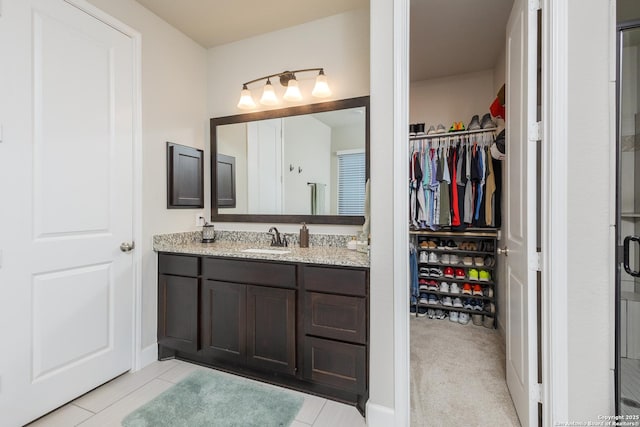 full bathroom with a spacious closet and vanity