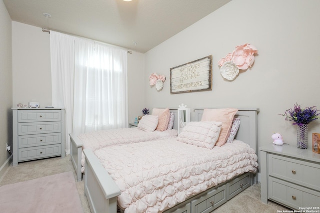 bedroom with light colored carpet and baseboards