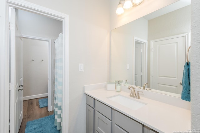 bathroom featuring baseboards, wood finished floors, and vanity