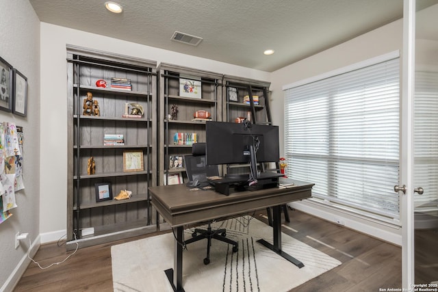 office space featuring visible vents, wood finished floors, baseboards, recessed lighting, and a textured ceiling
