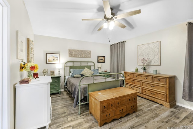 bedroom with a ceiling fan and light wood-style flooring