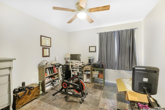 interior space featuring baseboards and a ceiling fan