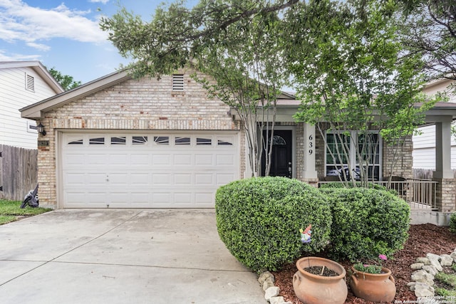 view of front of property featuring brick siding, a garage, fence, and concrete driveway