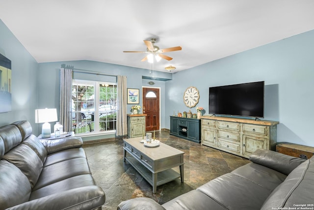 living room featuring stone tile flooring, ceiling fan, and lofted ceiling