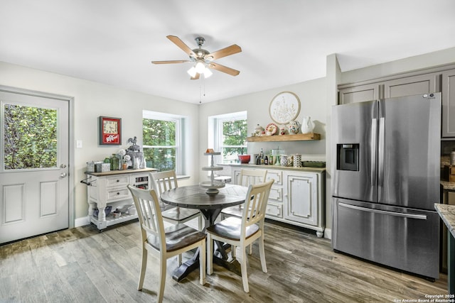 dining area featuring a ceiling fan, baseboards, and wood finished floors
