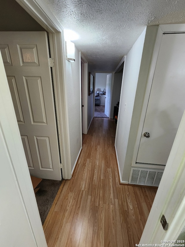 4802 Castle Brg, San Antonio, TX 78218 - corridor with wood finished floors, a textured ceiling, and baseboards