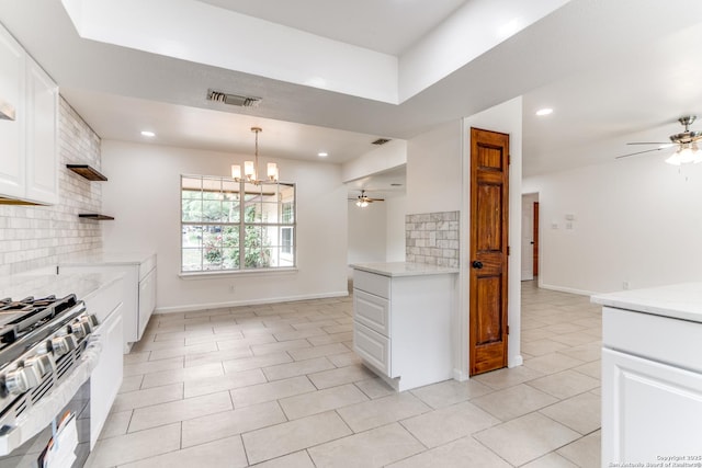 10526 Tioga, San Antonio, TX 78230 - kitchen featuring stainless steel range with gas stovetop, ceiling fan with notable chandelier, white cabinetry, backsplash, and visible vents