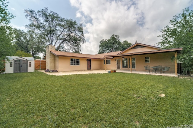10526 Tioga, San Antonio, TX 78230 - back of property featuring ceiling fan, a chimney, a storage shed, a lawn, and a patio