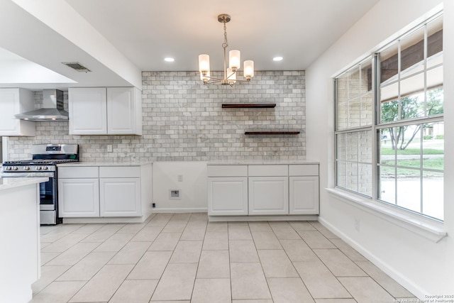 10526 Tioga, San Antonio, TX 78230 - kitchen with visible vents, stainless steel gas stove, wall chimney range hood, light countertops, and a chandelier