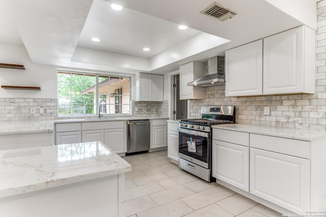 10526 Tioga, San Antonio, TX 78230 - kitchen featuring appliances with stainless steel finishes, a sink, wall chimney exhaust hood, light tile patterned floors, and visible vents