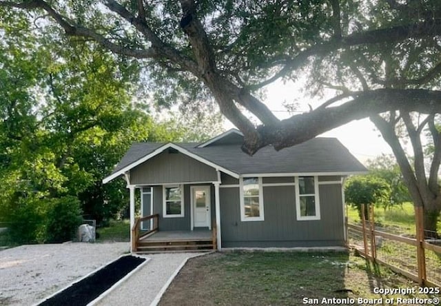 view of front of property with a porch and fence