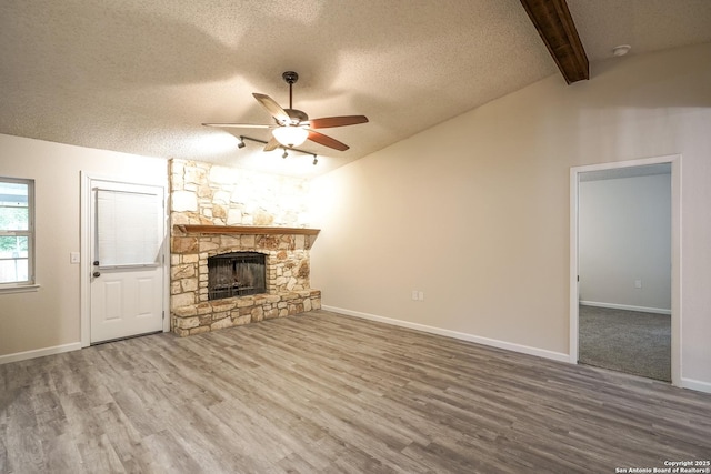 unfurnished living room featuring a ceiling fan, a textured ceiling, and wood finished floors