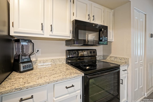 kitchen featuring white cabinets, light stone countertops, and black appliances