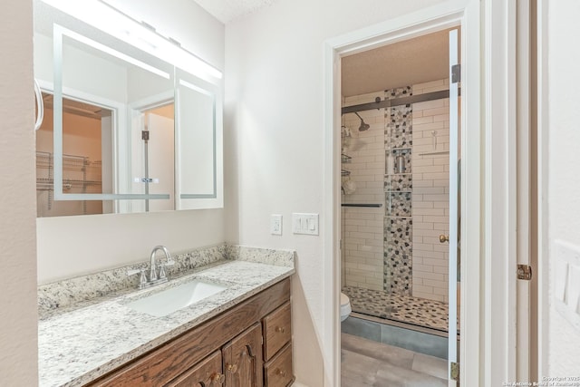 bathroom with vanity, toilet, and a stall shower