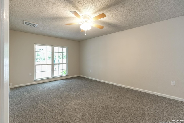 spare room with visible vents, baseboards, ceiling fan, and dark colored carpet