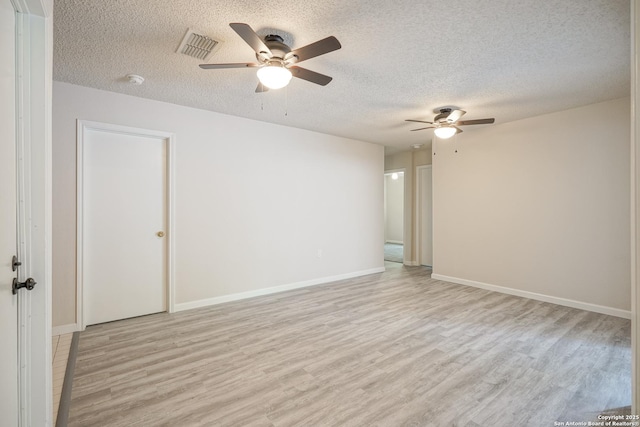 empty room featuring visible vents, baseboards, a textured ceiling, a ceiling fan, and light wood-style flooring
