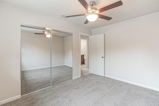 unfurnished bedroom featuring carpet floors, a ceiling fan, a textured ceiling, and a closet