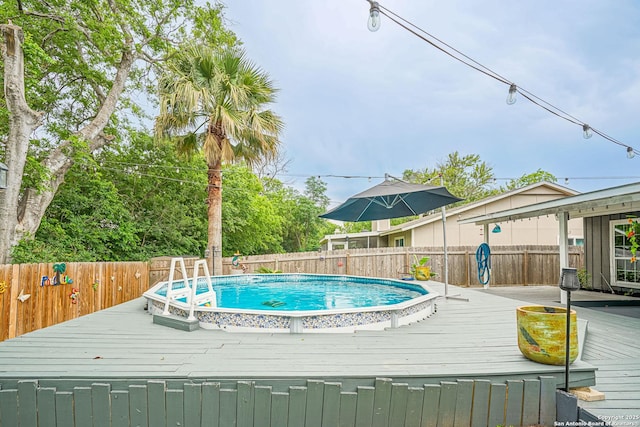 view of swimming pool with a fenced backyard, a fenced in pool, and a wooden deck