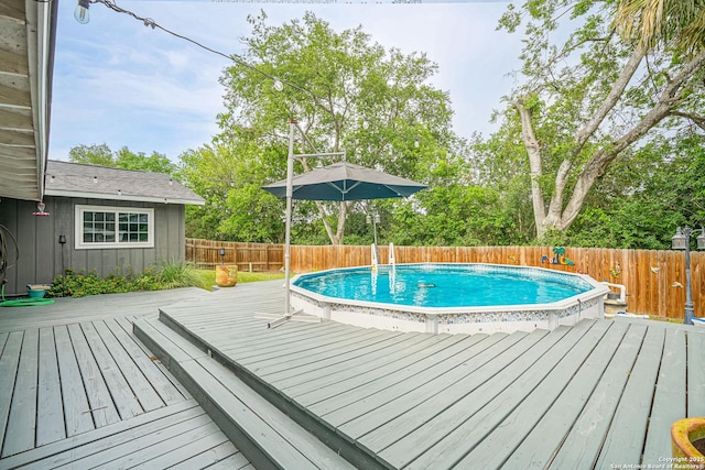 view of pool featuring a deck, a fenced in pool, and a fenced backyard