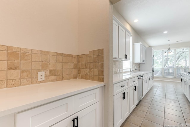 kitchen with light countertops, white cabinetry, light tile patterned floors, and a sink