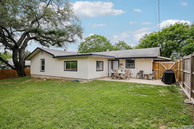 rear view of property with a fenced backyard, a yard, and a patio area