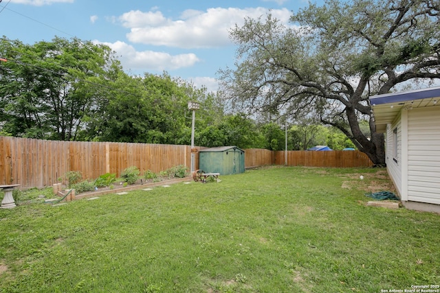 view of yard featuring a fenced backyard, a storage unit, and an outbuilding