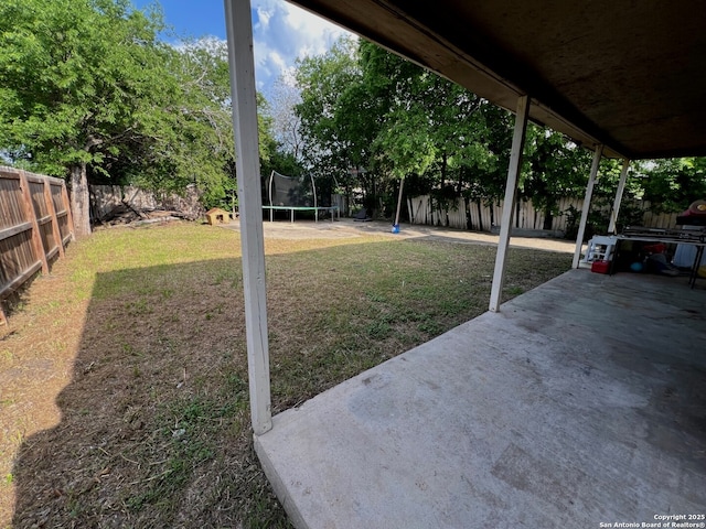 view of yard with a patio, a fenced backyard, and a trampoline