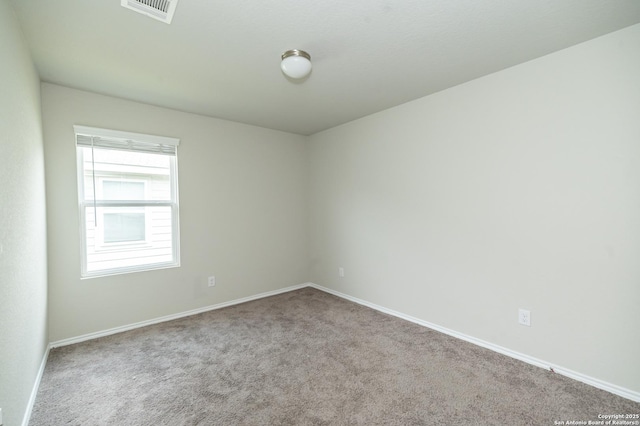 spare room featuring carpet floors, baseboards, and visible vents