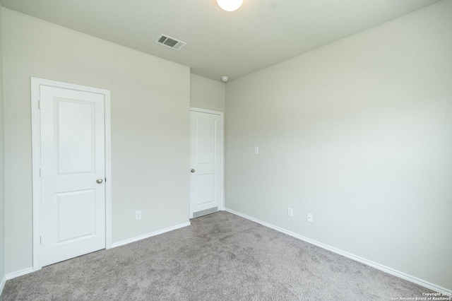 unfurnished bedroom featuring baseboards, visible vents, and carpet