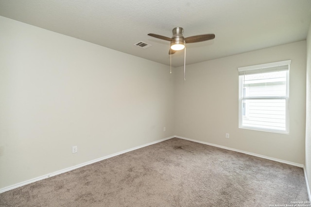 carpeted empty room featuring baseboards, ceiling fan, and visible vents
