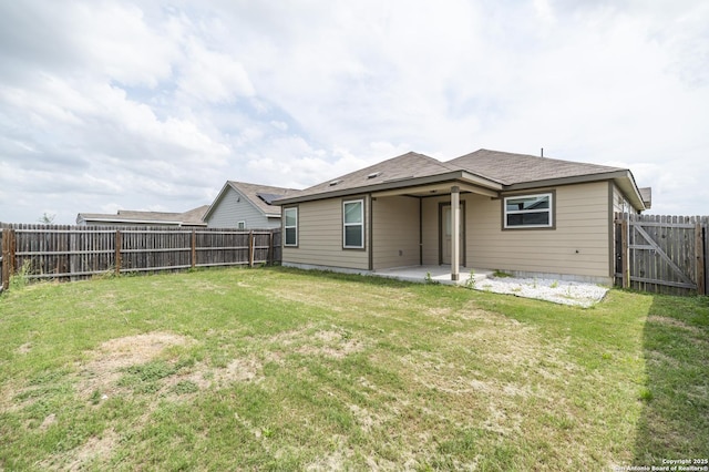 rear view of house with a lawn, a patio, and a fenced backyard