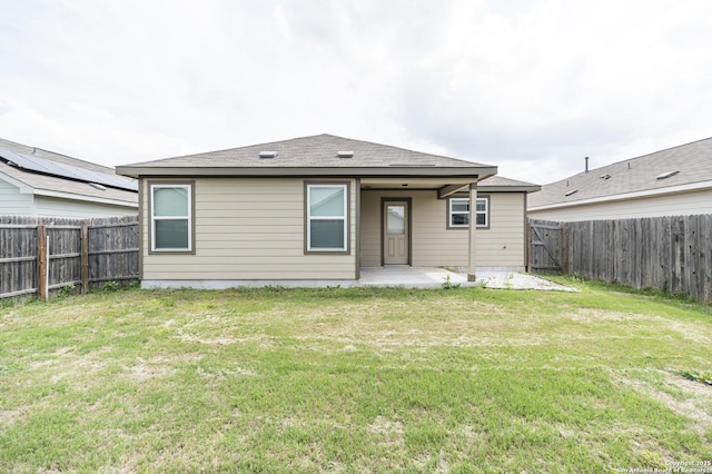 back of house with a lawn, a fenced backyard, and a patio area