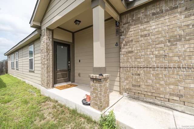 view of exterior entry featuring brick siding