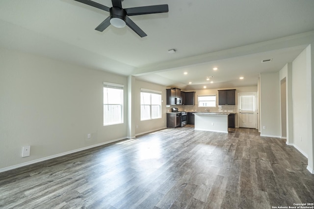 unfurnished living room featuring baseboards, recessed lighting, dark wood finished floors, and ceiling fan